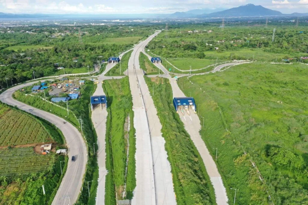 Aerial view of the CALAX highway with toll booths surrounded by green landscape, an example of Public-Private Partnerships Philippines projects.