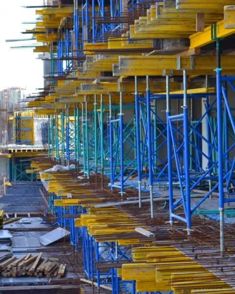 Construction Safety Standards Philippines: Construction site with colorful scaffolding and building materials, with cityscape in the background.