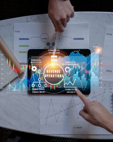 Philippines Digital Economy Growth: A hands-on meeting analyzing revenue operations with graphs and digital data on a tablet, surrounded by notes and a calculator.