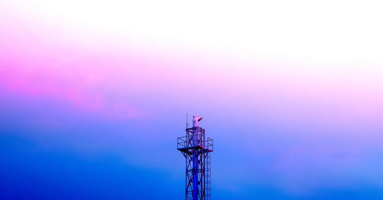 A tall communication tower against a gradient sky, transitioning from pink to blue, with crisp lines and a modern design, representing Philippines Telecom Tower Expansion.