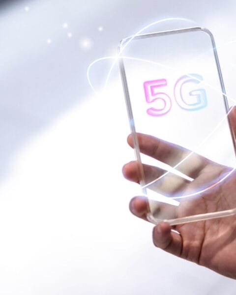 Philippines 5G Rural Expansion: A hand holds a sleek, modern smartphone displaying a colorful "5G" logo, surrounded by glowing, dynamic lines.